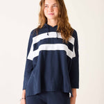 Woman wearing a navy blue hoodie with white stripes on a plain background