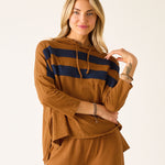 Woman wearing a brown hoodie with navy stripes and matching pants on a white background