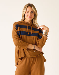 Woman wearing a brown hoodie with navy stripes and matching pants on a white background