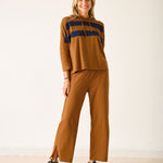 Woman wearing a brown outfit with navy accents on a white background
