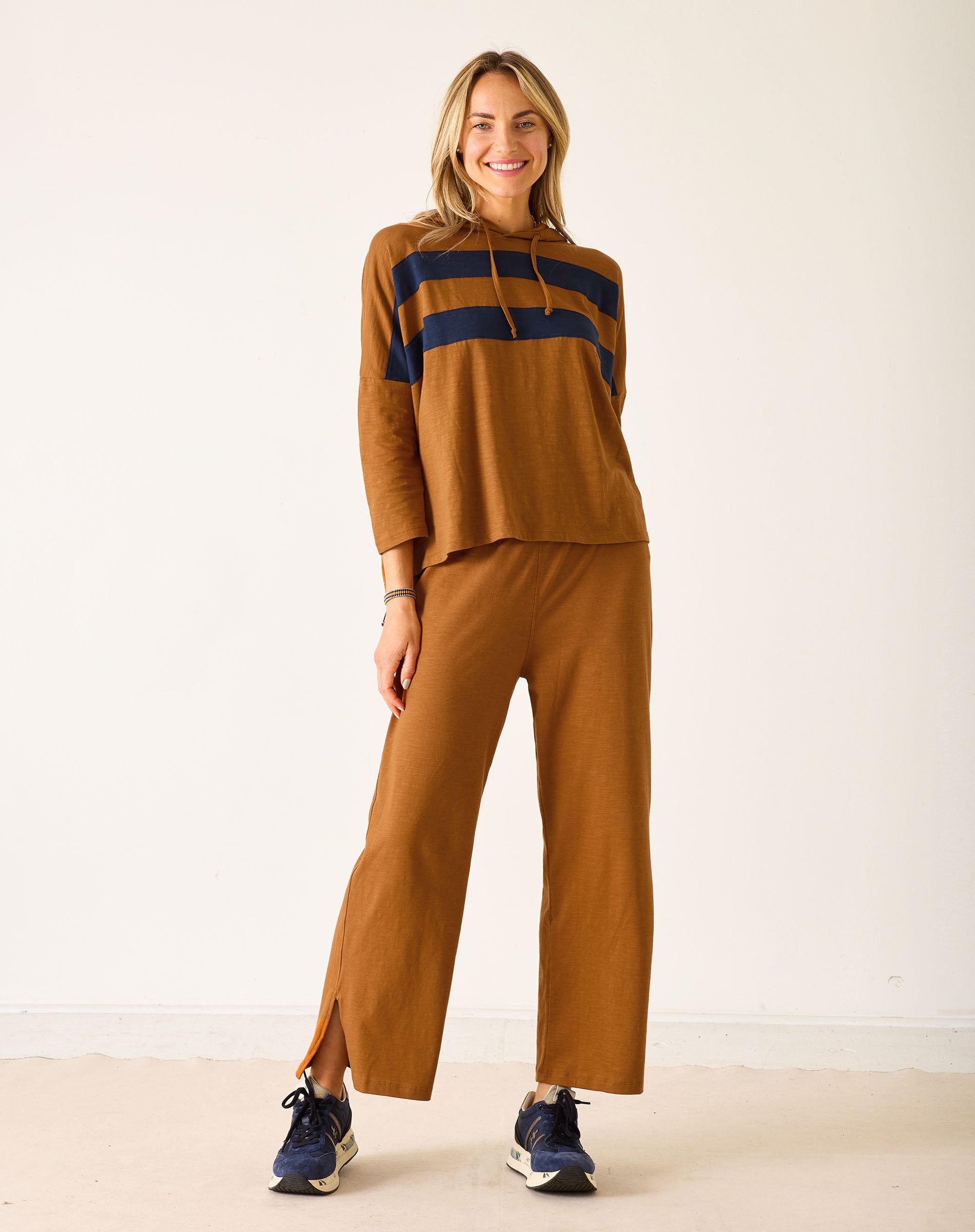 Woman wearing a brown outfit with navy accents on a white background