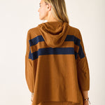 Person wearing a brown hoodie with blue stripes on a white background