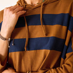 Close-up of a person wearing a brown and navy striped hoodie.