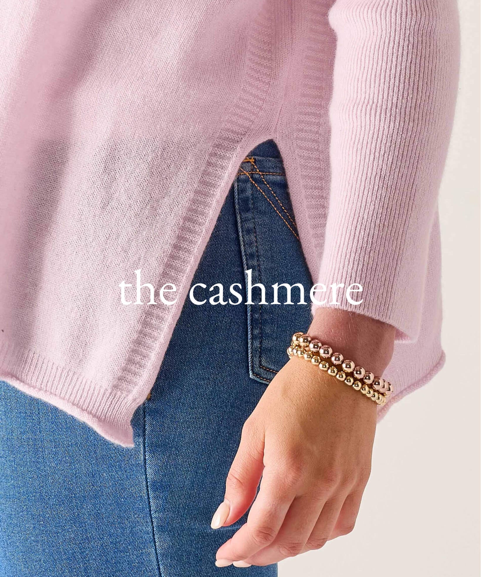 Pink sweater and blue jeans with 'the cashmere' text on a light background