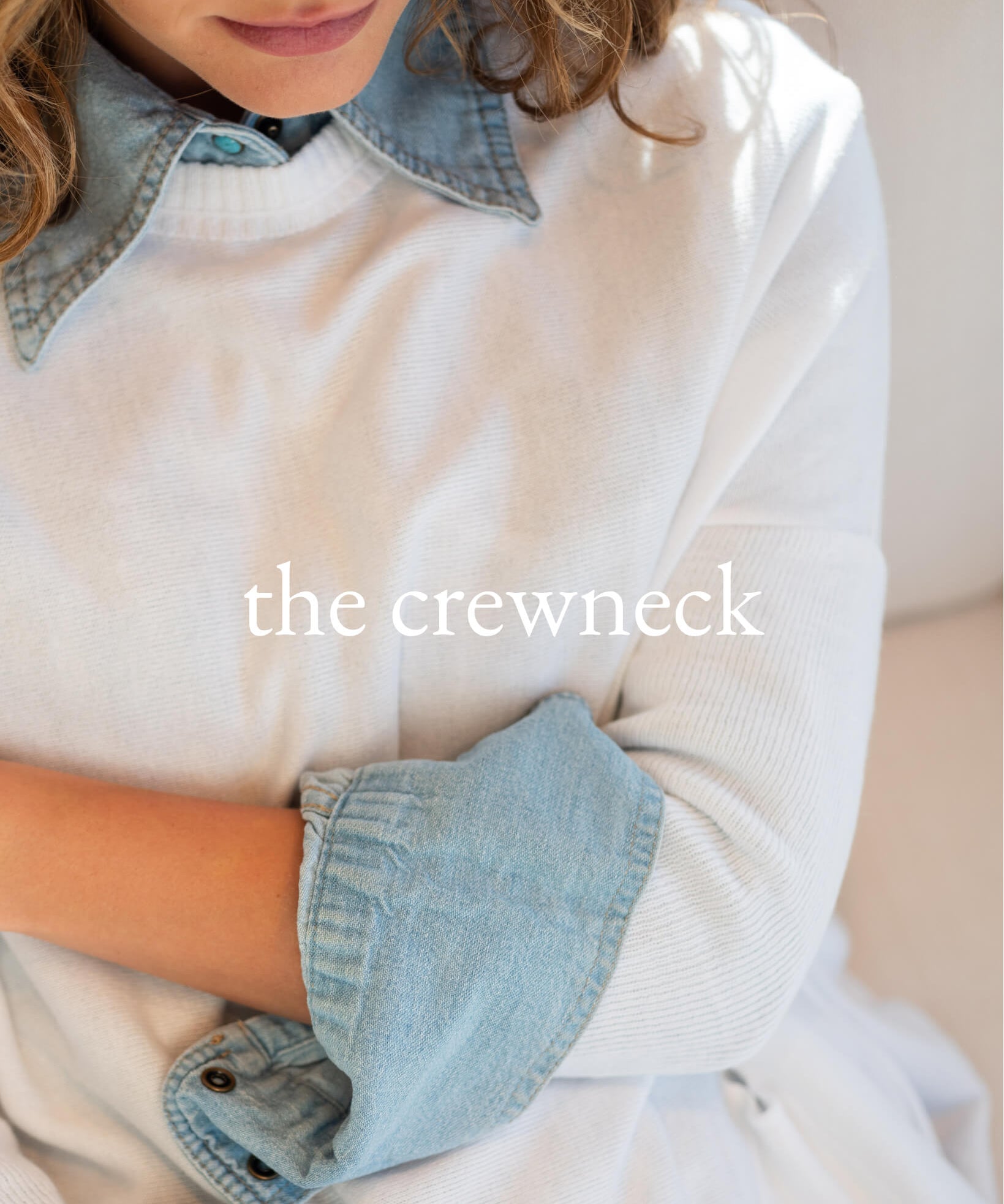 Person wearing a white shirt with denim collar and cuffs, text 'the crewneck' overlayed.