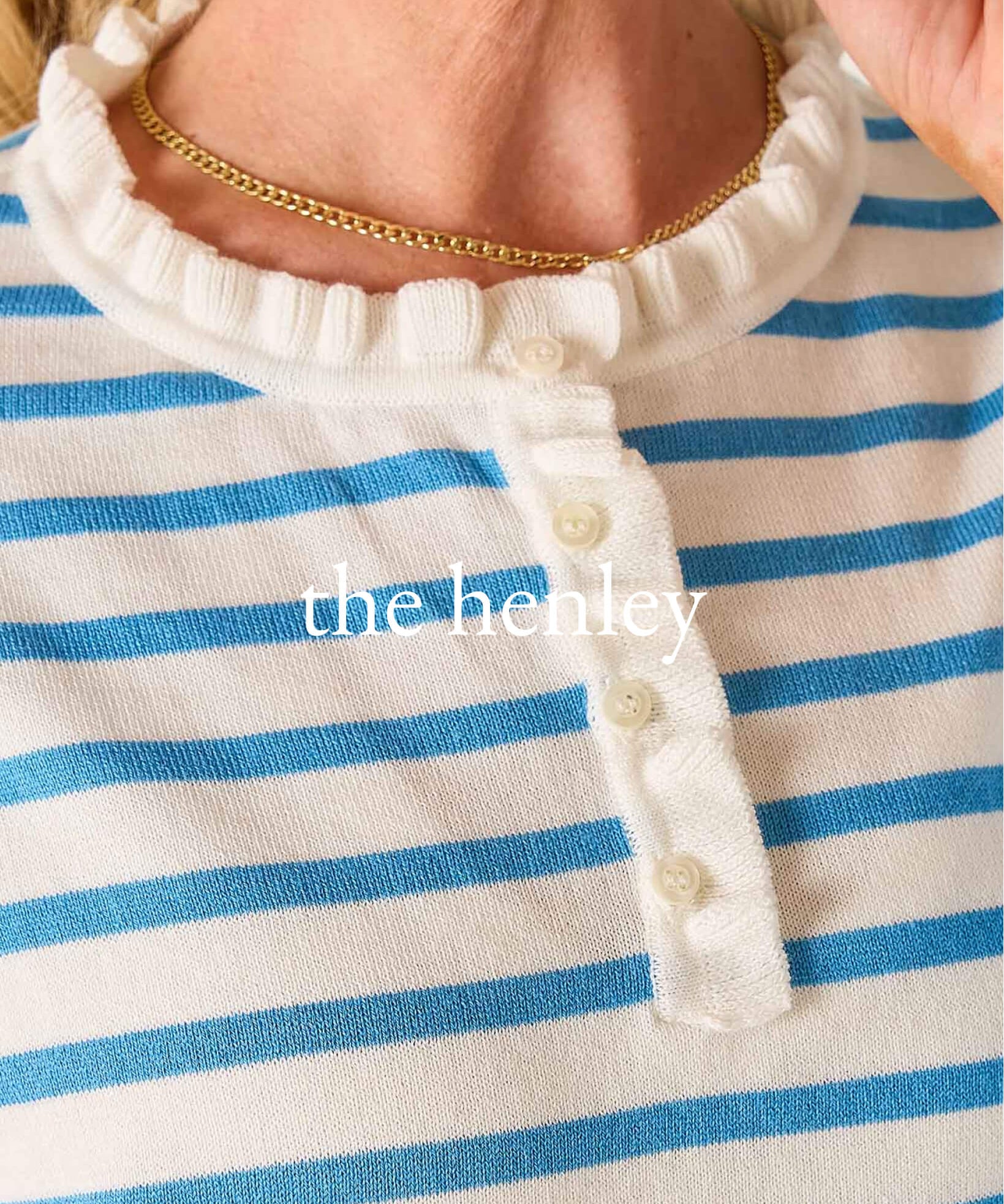 Close-up of a blue and white striped garment with 'the henley' branding.