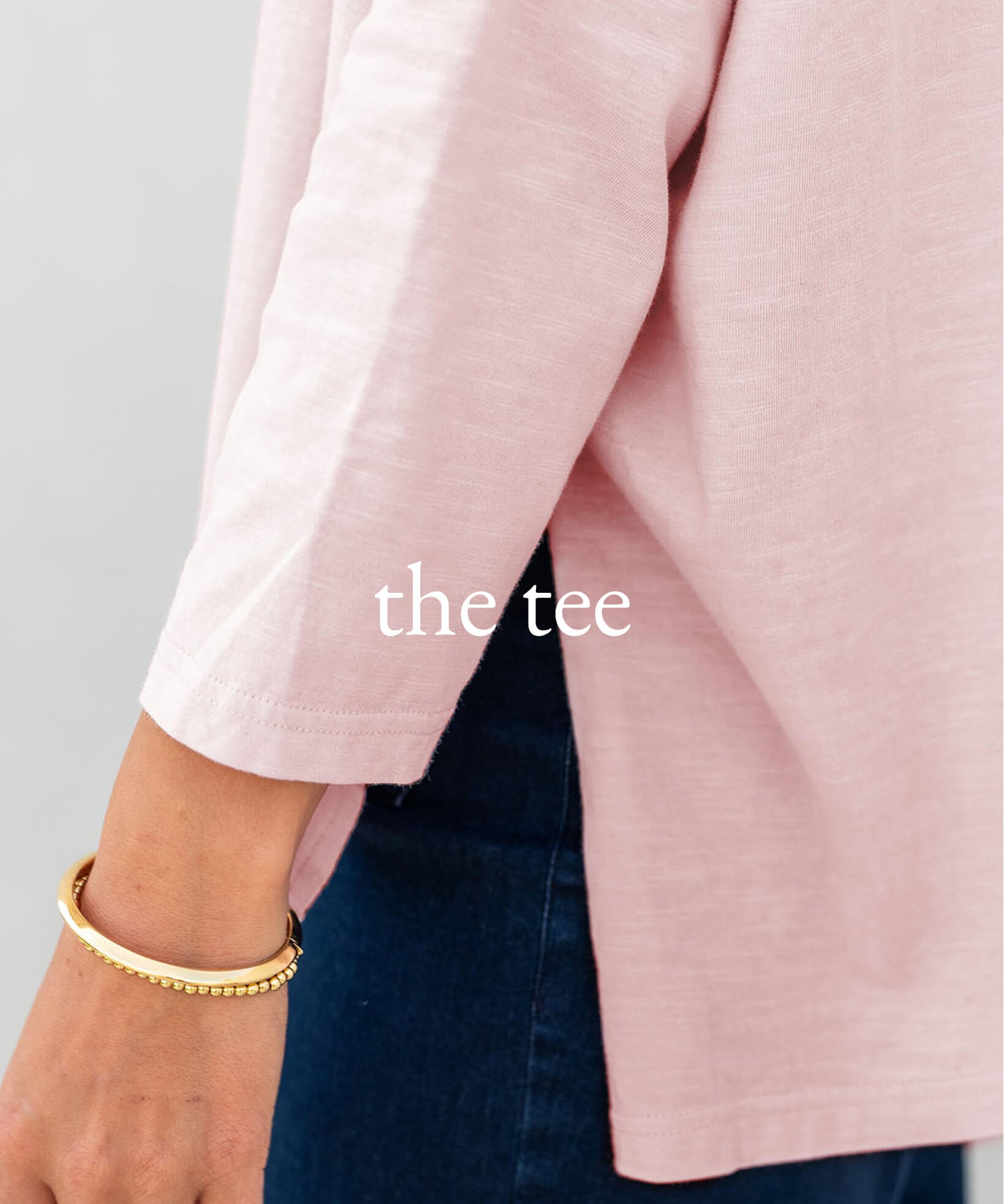 Close-up of a pink garment with 'the tee' text on a gray background