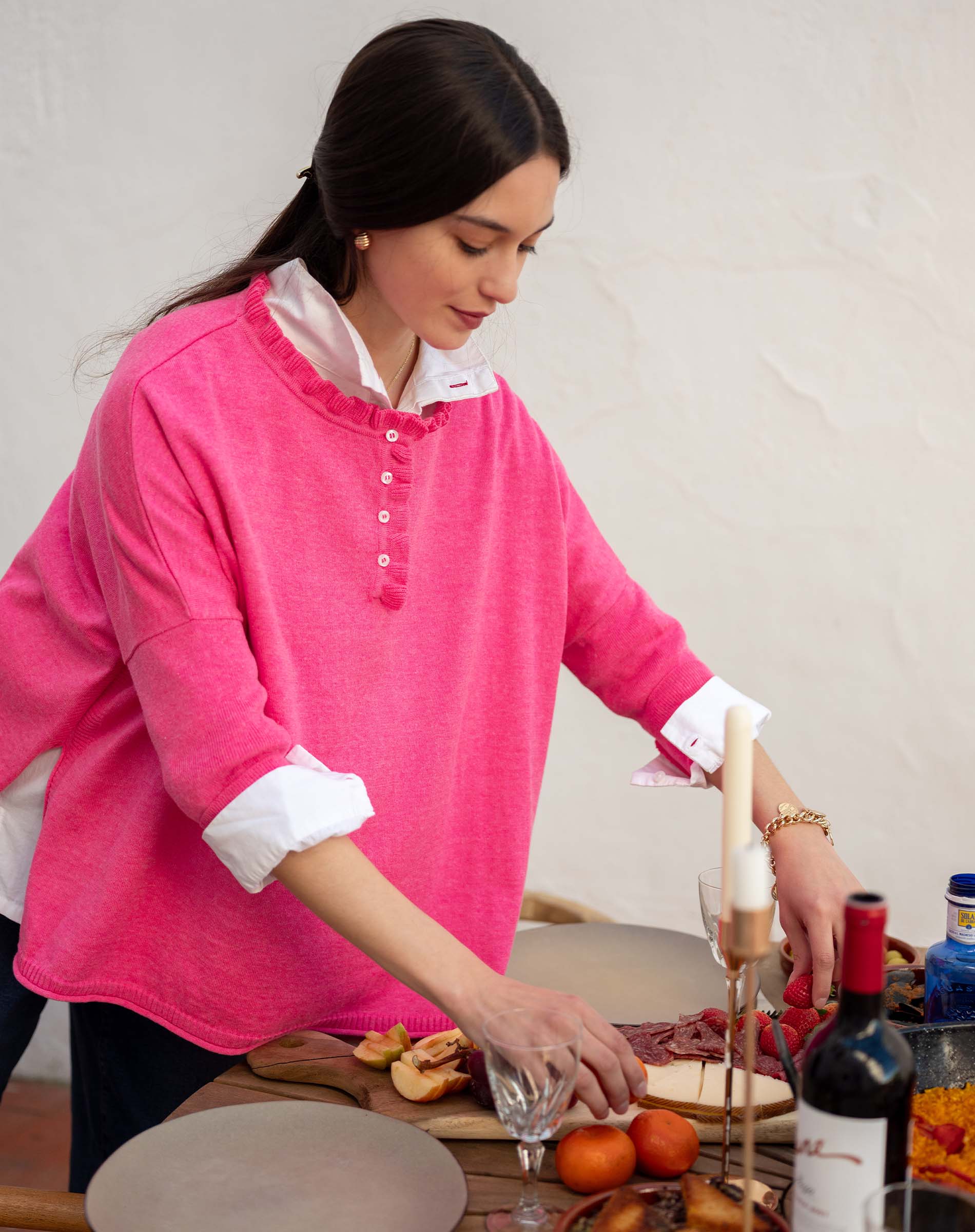Fuchsia ruffle henley top with a buttoned placket and flared sleeves over a white shirt.