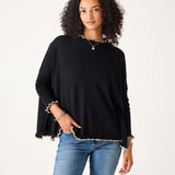 Women's travel-friendly black sweater with taupe ruffled trim and long sleeves.