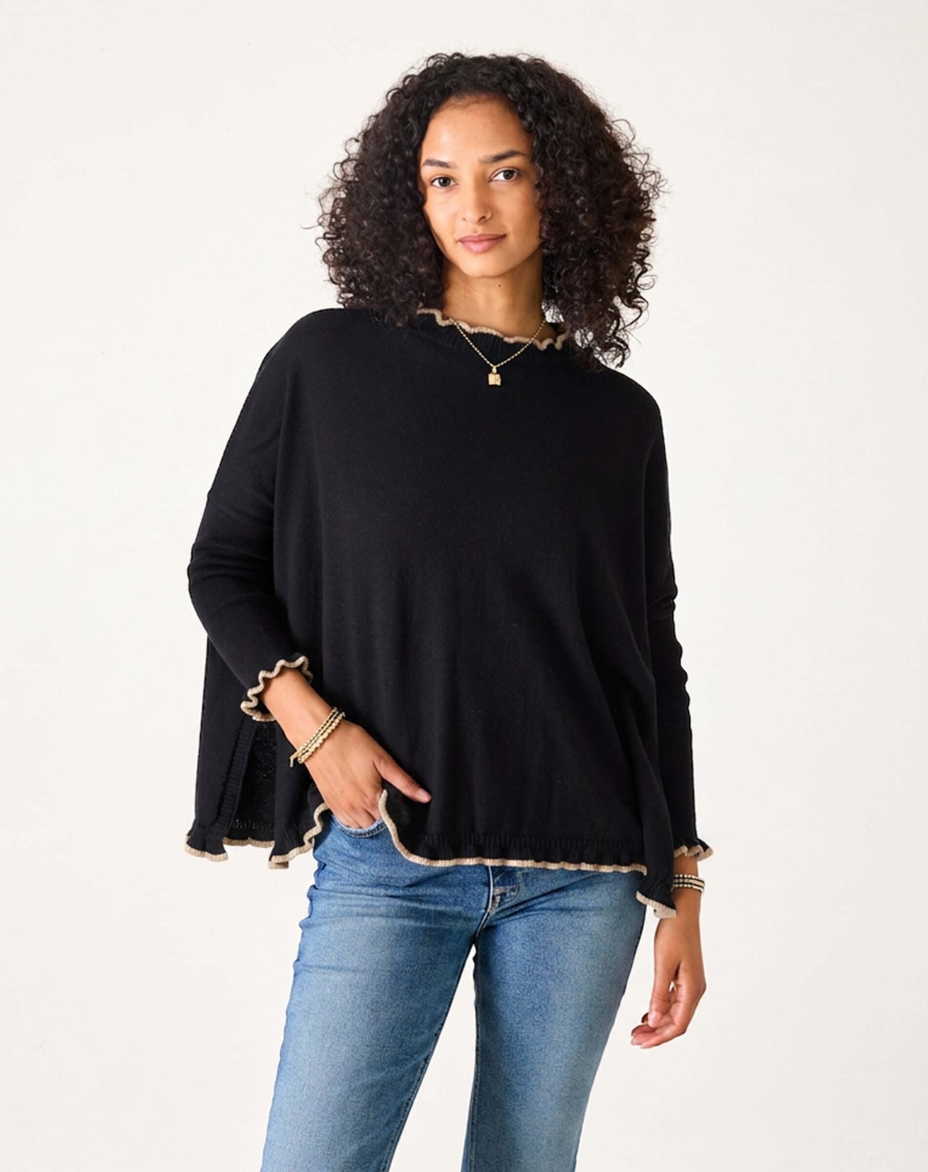 Women's travel-friendly black sweater with taupe ruffled trim and long sleeves.