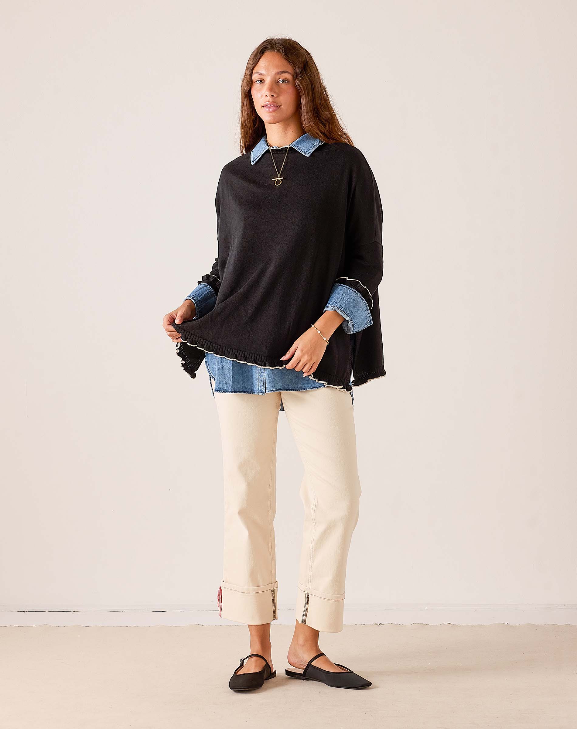 MERSEA ladies' travel-ready black knit Catalina ruffle sweater with a relaxed fit and feminine ruffled hem.