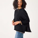Black knit sweater with ruffled trim and side slits in the Catalina Ruffle Sweater.