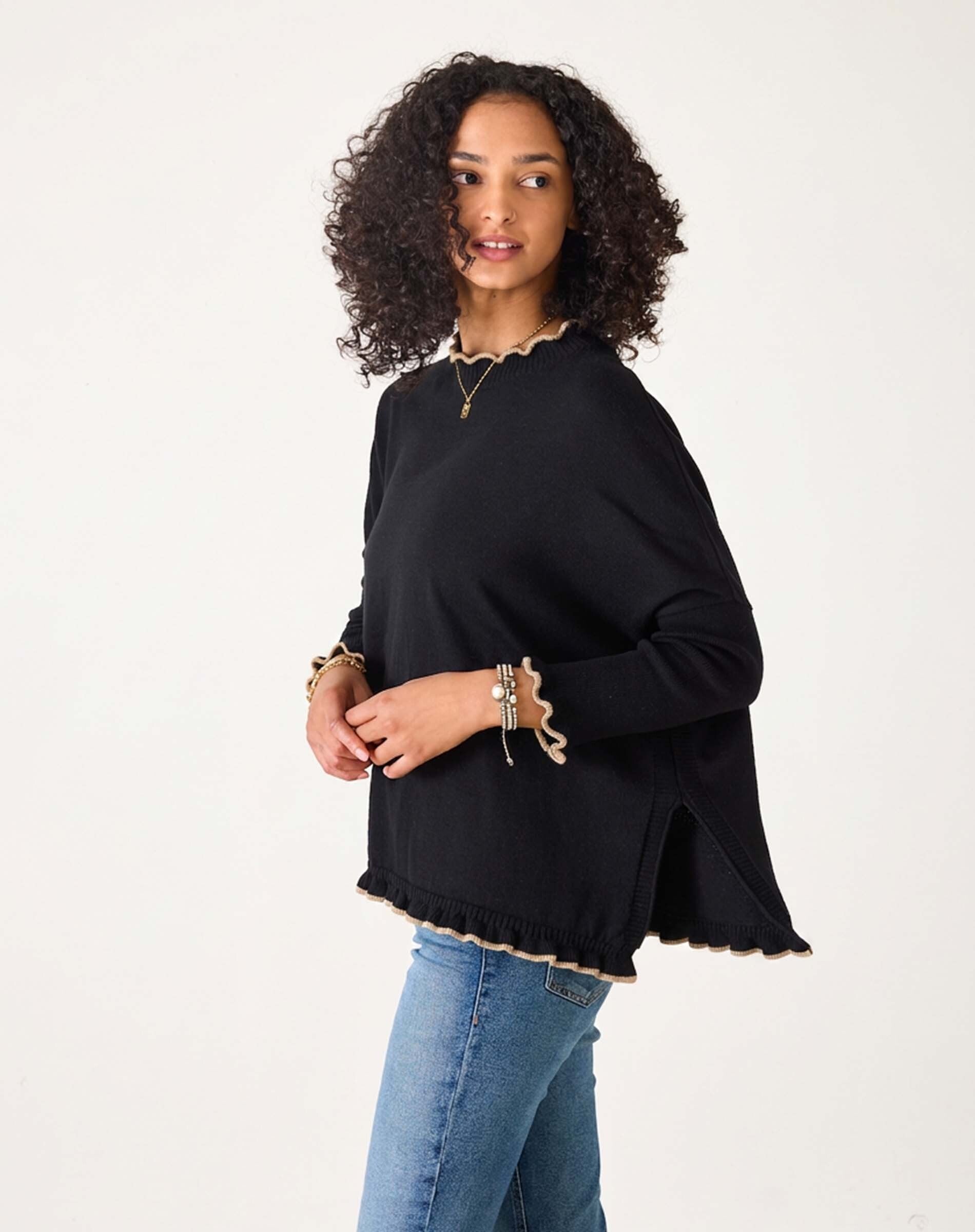 Black knit sweater with ruffled trim and side slits in the Catalina Ruffle Sweater.