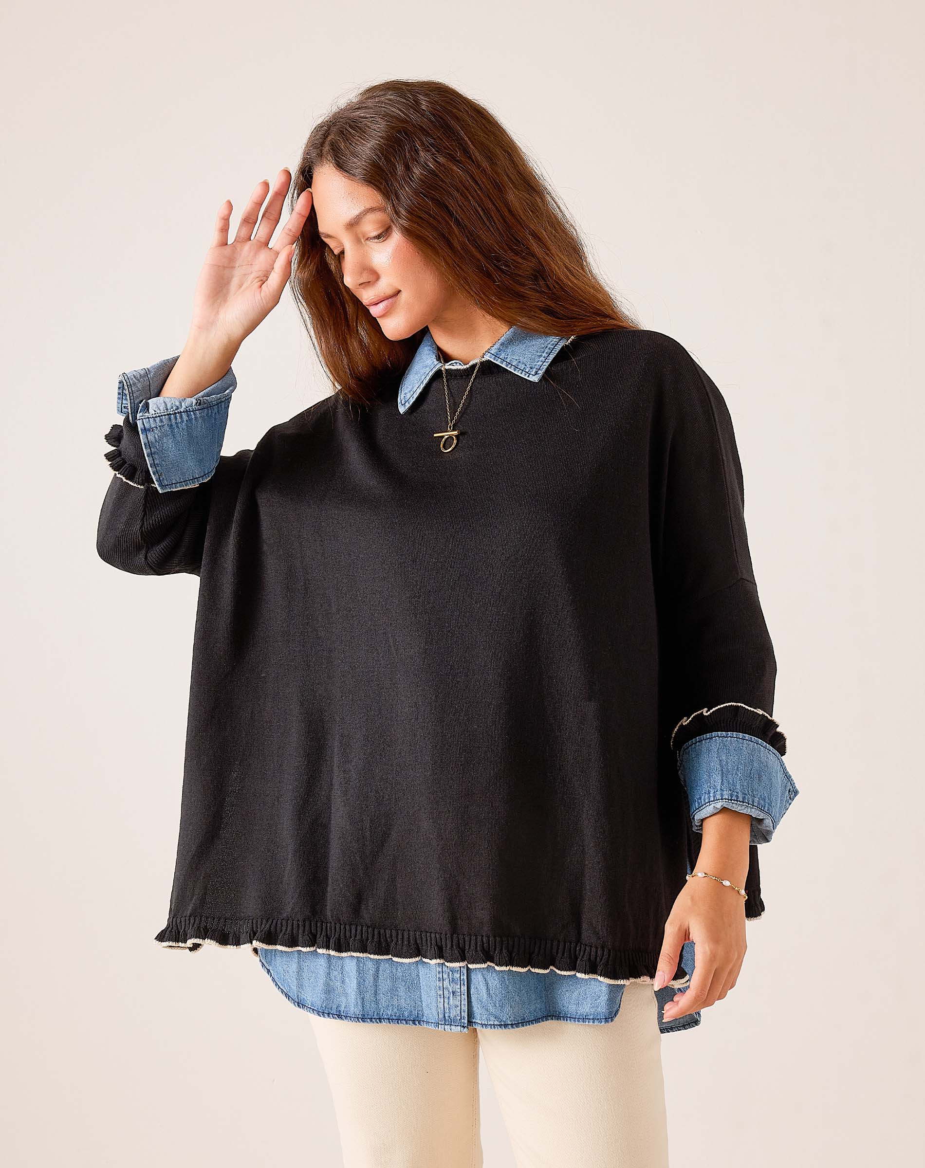Black and taupe ruffled oversized sweater with denim collar and cuff details.
