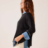 Black knit Catalina ruffle sweater with ruffled hem and contrasting blue denim-style layers.