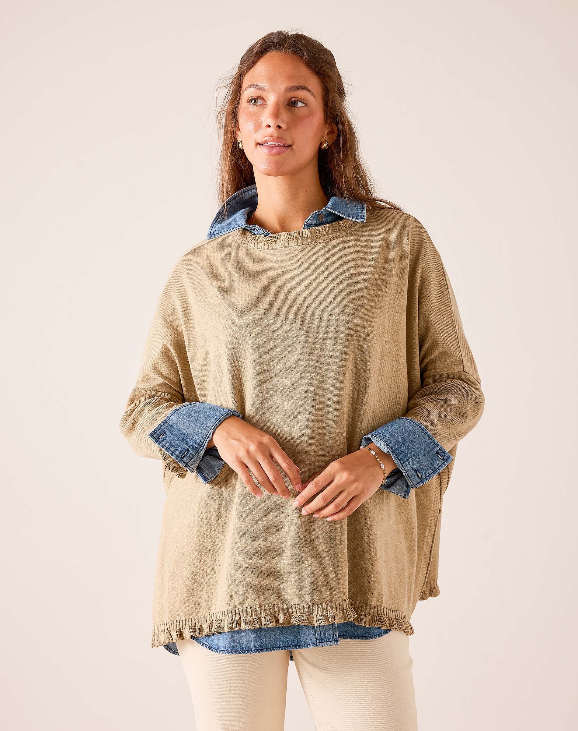 Saddle brown oversized knit sweater featuring a layered denim shirt look with ruffled hem and wide sleeves.