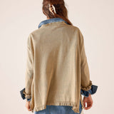 Back view of women's travel-friendly saddle-colored knit Catalina ruffle sweater with ruffled hem and cuffs over a denim shirt.
