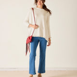 Warm white ruffled knit top with flared sleeves and a wide hem