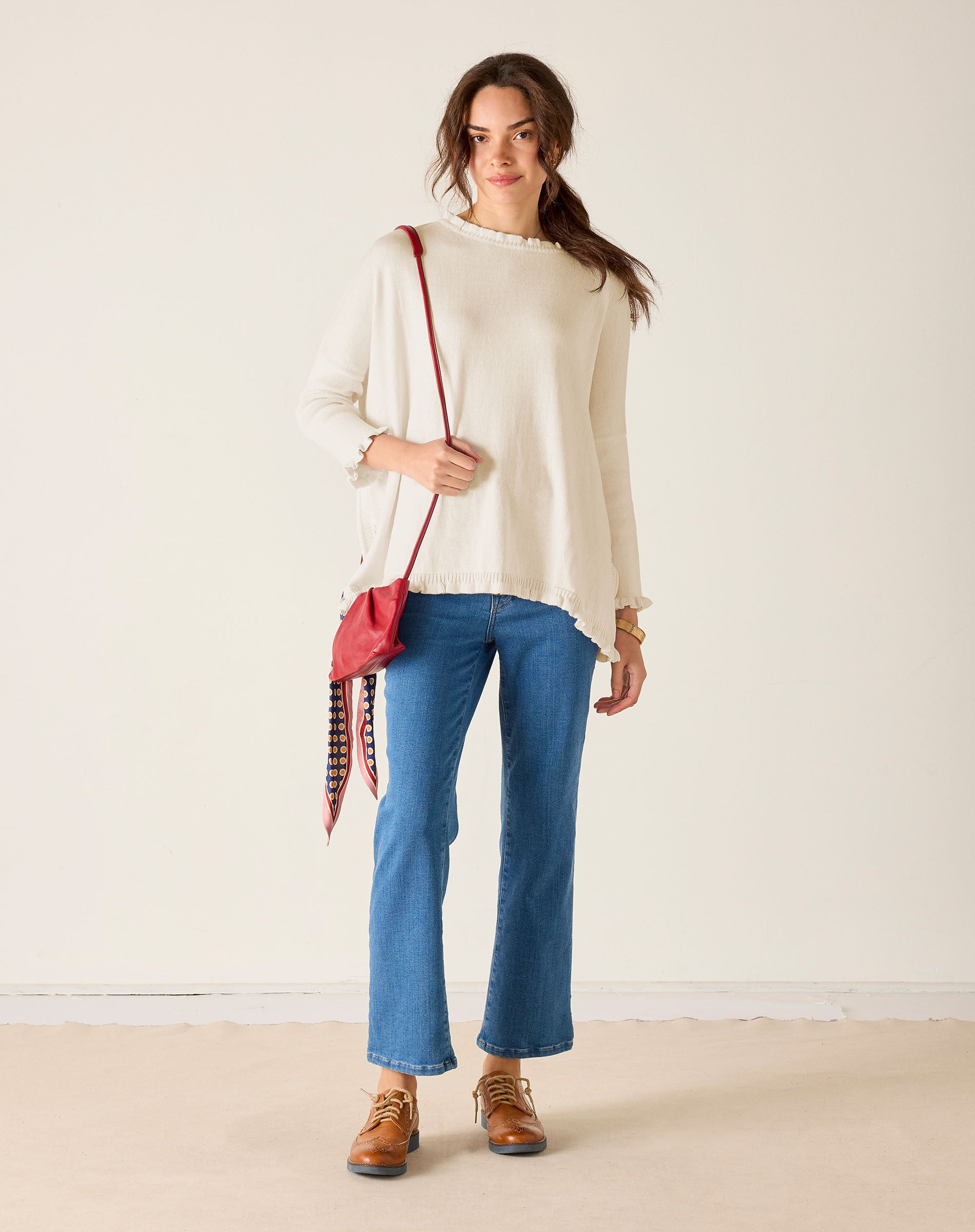 Warm white ruffled knit top with flared sleeves and a wide hem
