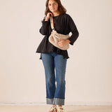 Women's travel-friendly black ruffled tee with a relaxed fit and soft cotton fabric.