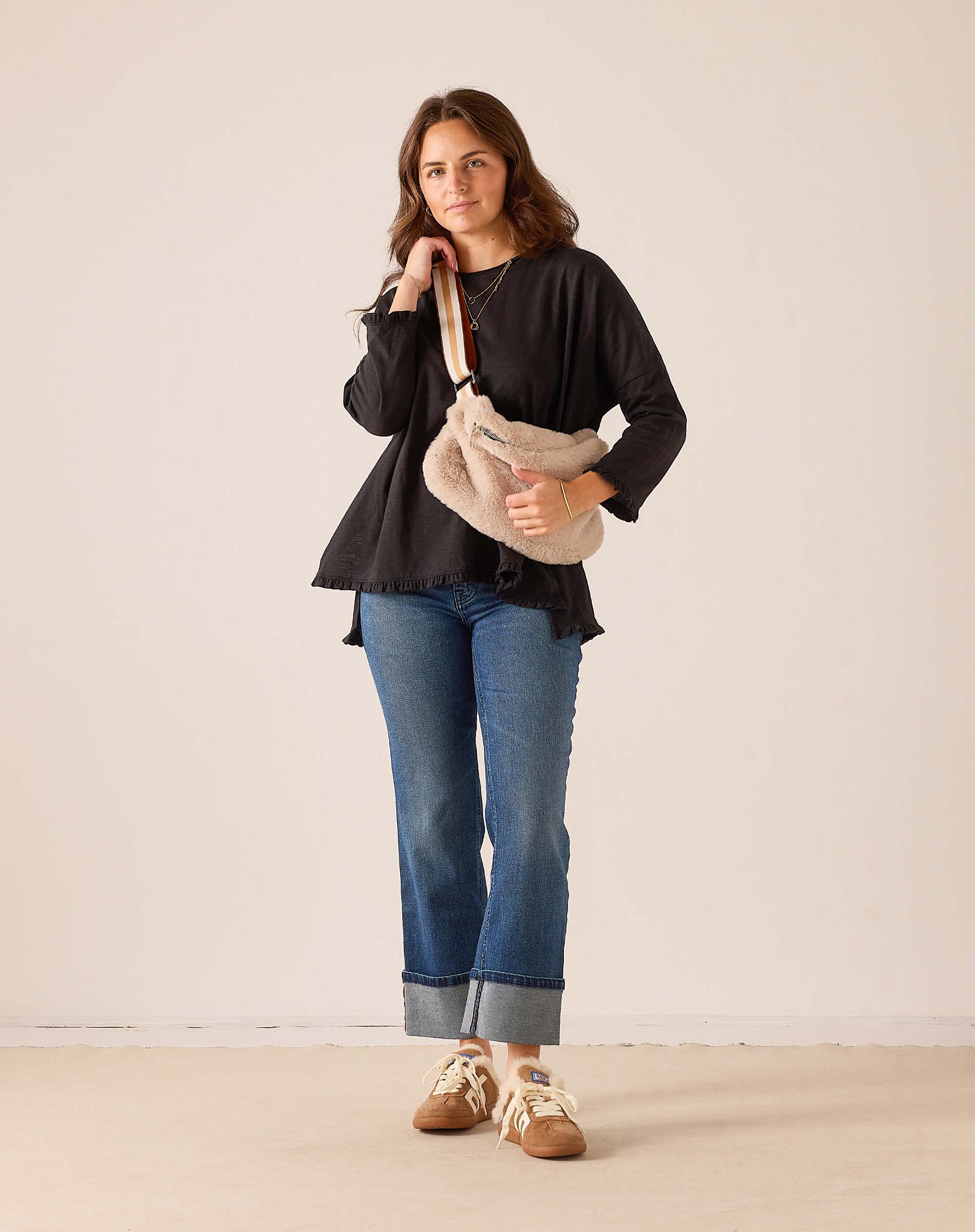 Women's travel-friendly black ruffled tee with a relaxed fit and soft cotton fabric.