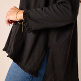 Black ruffled hem tee featuring a relaxed fit and soft cotton texture.