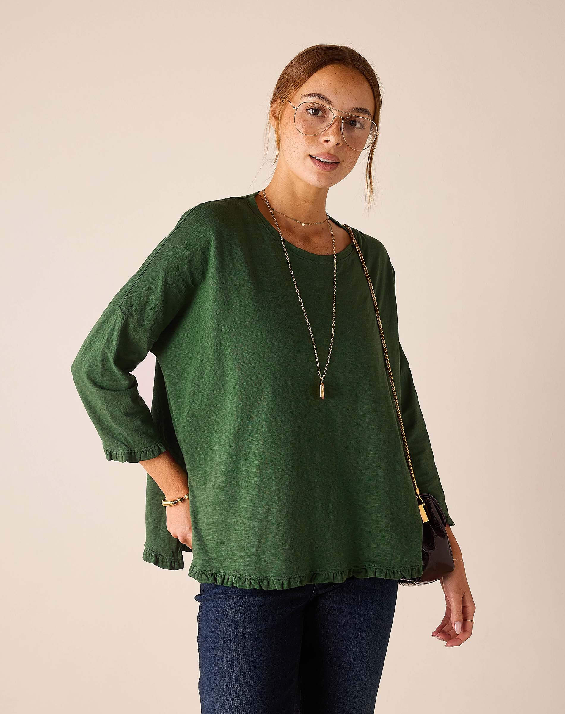 MERSEA ladies' travel-ready fairway green cotton knit ruffle tee with a relaxed fit and ruffled hem.