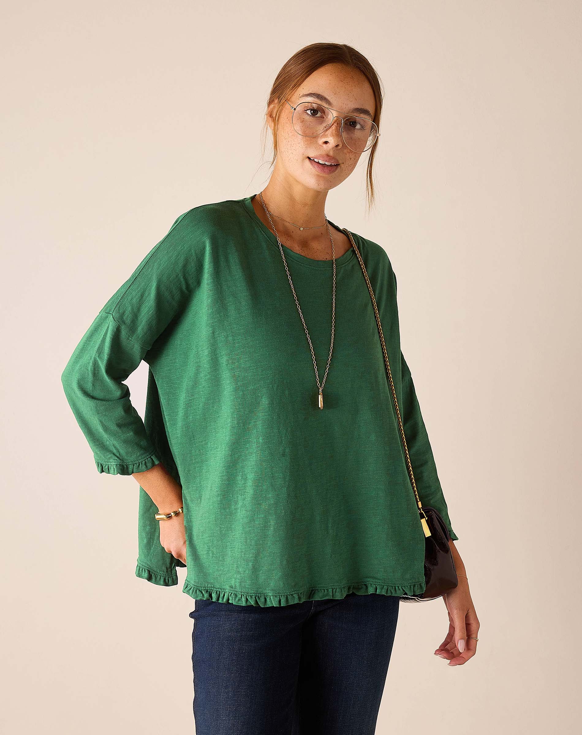 MERSEA ladies' travel-ready fairway green ruffle tee with 3/4 sleeves and a ruffled hem.