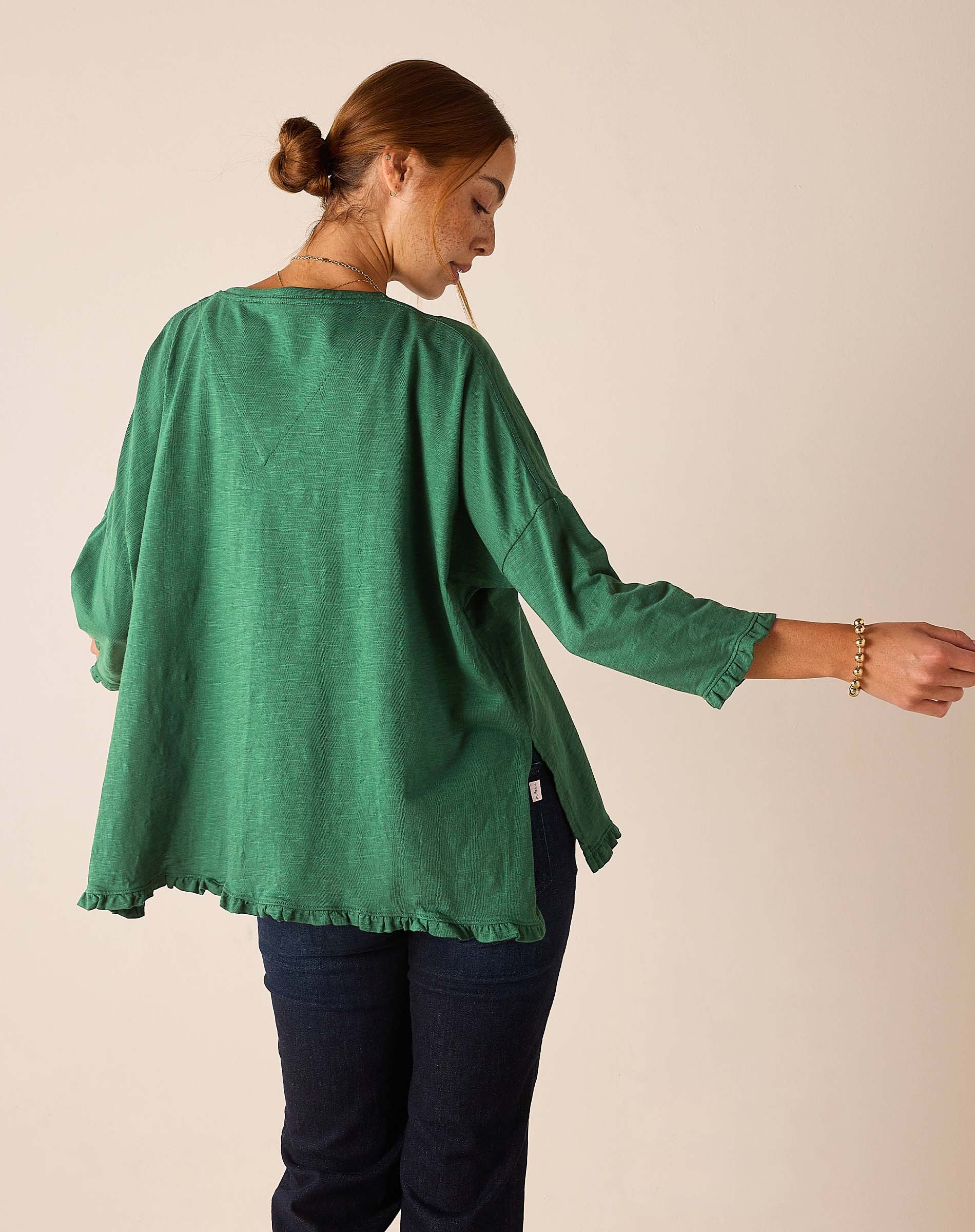 Back view of the fairway green Catalina ruffle tee featuring a relaxed fit and ruffled hem.