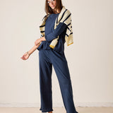 Woman wearing a navy outfit with a patterned cardigan against a plain background