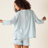 Woman wearing a light blue loungewear set with a plain background