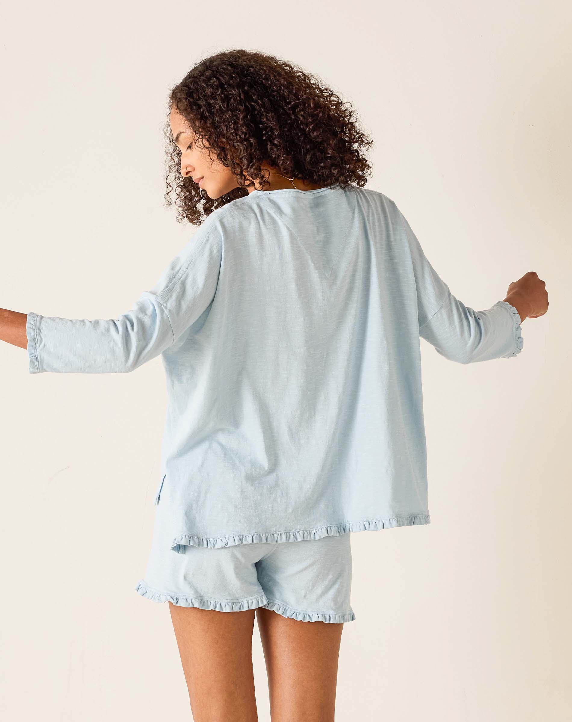 Woman wearing a light blue loungewear set with a plain background