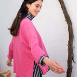 Rapture rose ruffled tee with striped trim and bell-style sleeves over a striped shirt.