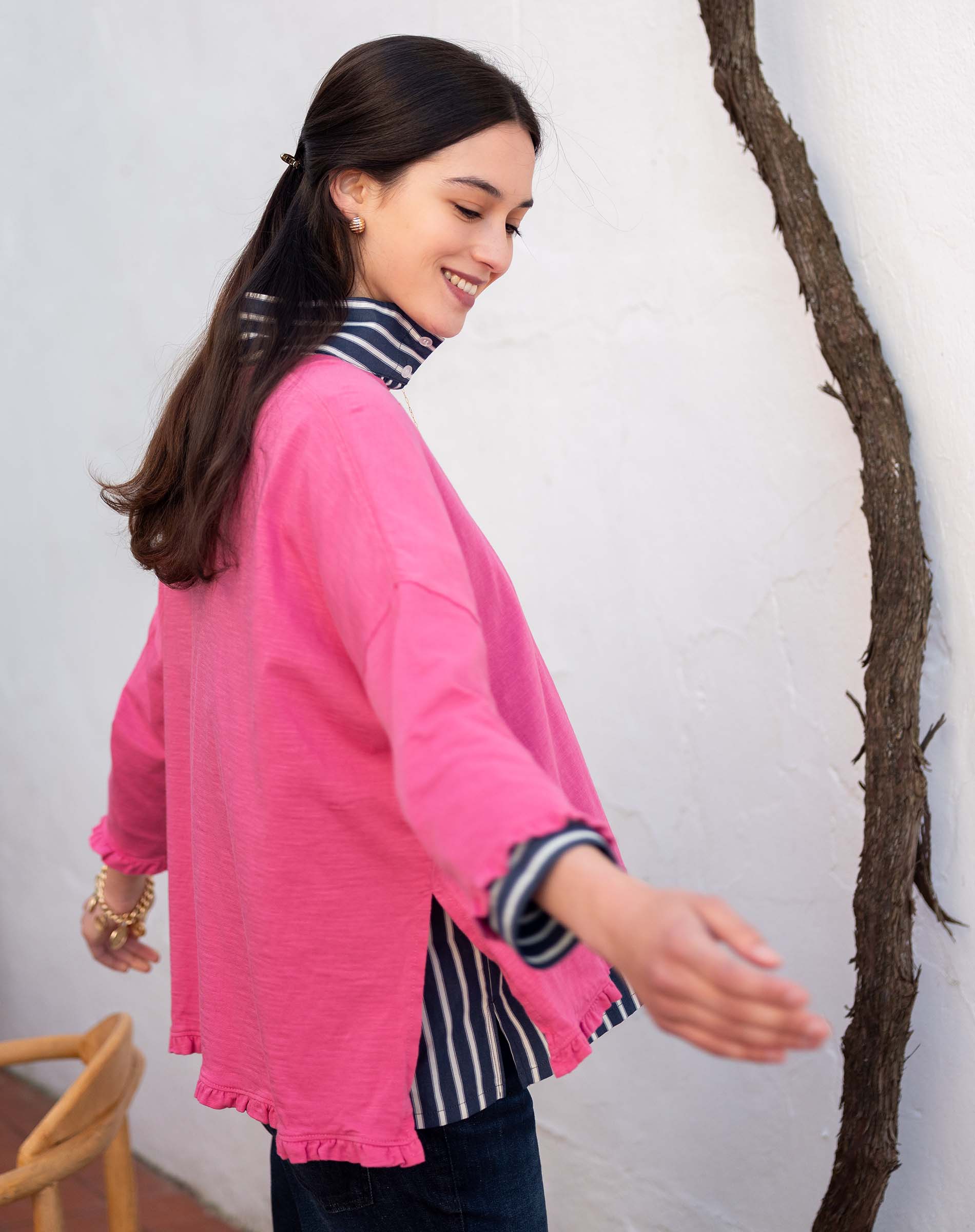 Rapture rose ruffled tee with striped trim and bell-style sleeves over a striped shirt.