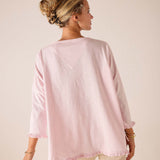 Back view of women's travel-friendly rose quartz loose-fit linen-blend tee with ruffle hem and wide sleeves.