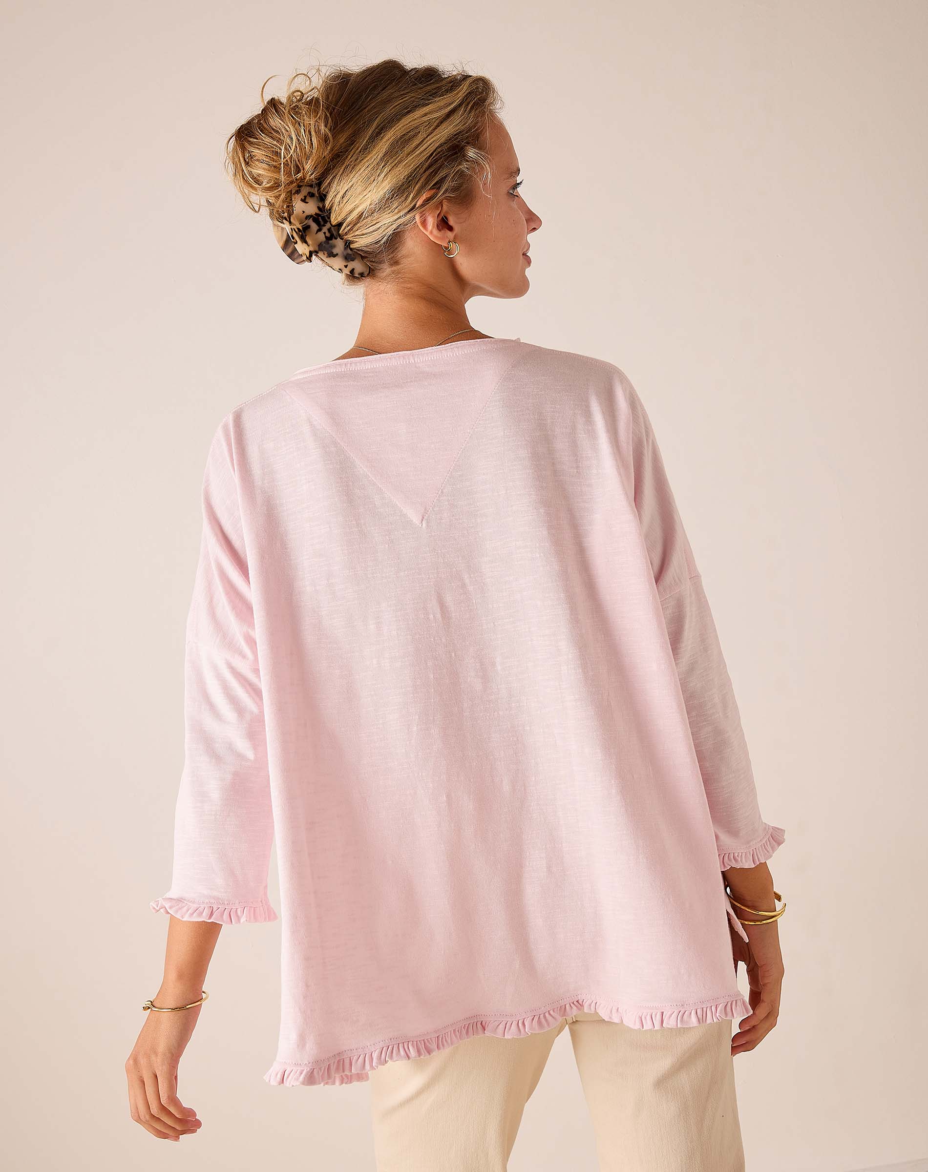 Back view of women's travel-friendly rose quartz loose-fit linen-blend tee with ruffle hem and wide sleeves.