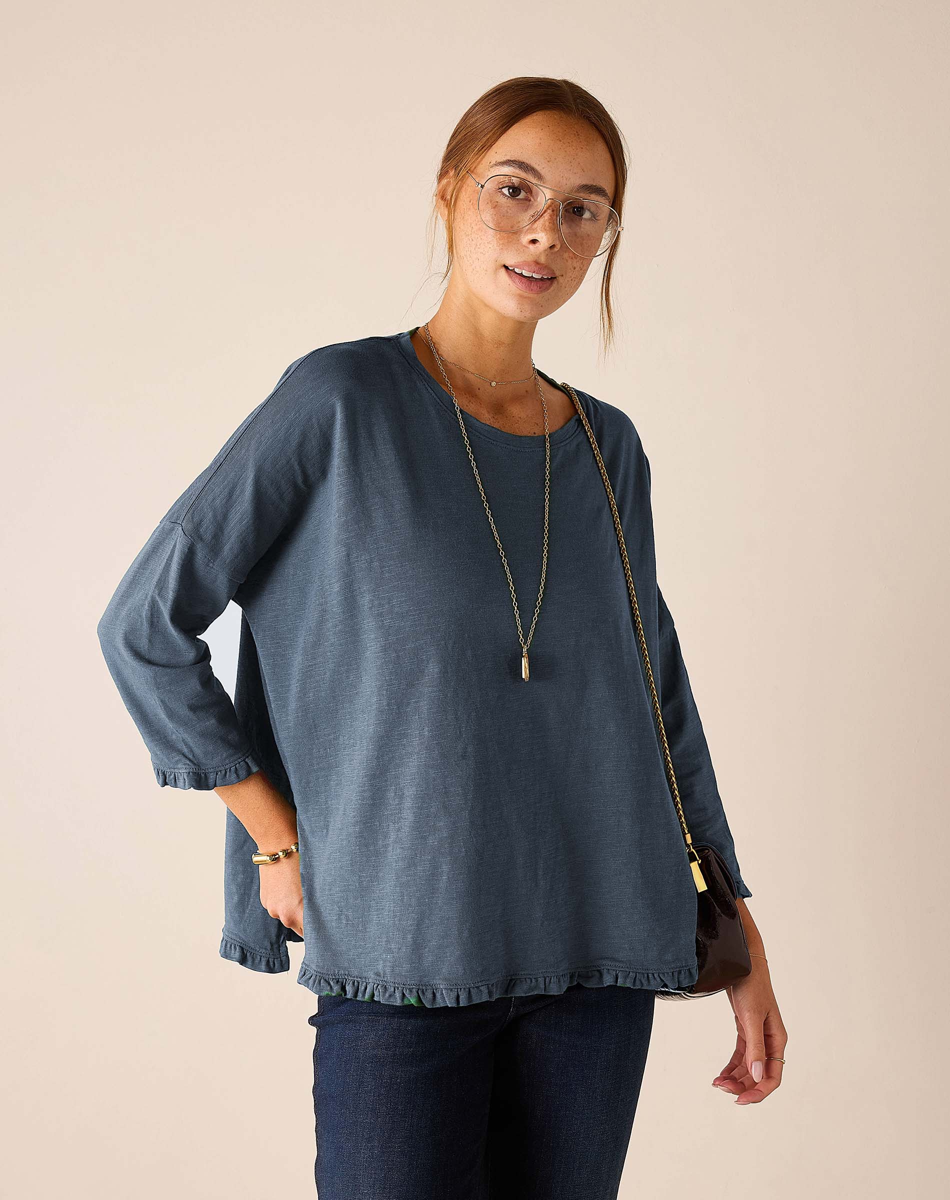 MERSEA women's travel-friendly slate blue ruffle tee with three-quarter length sleeves and a draped silhouette.