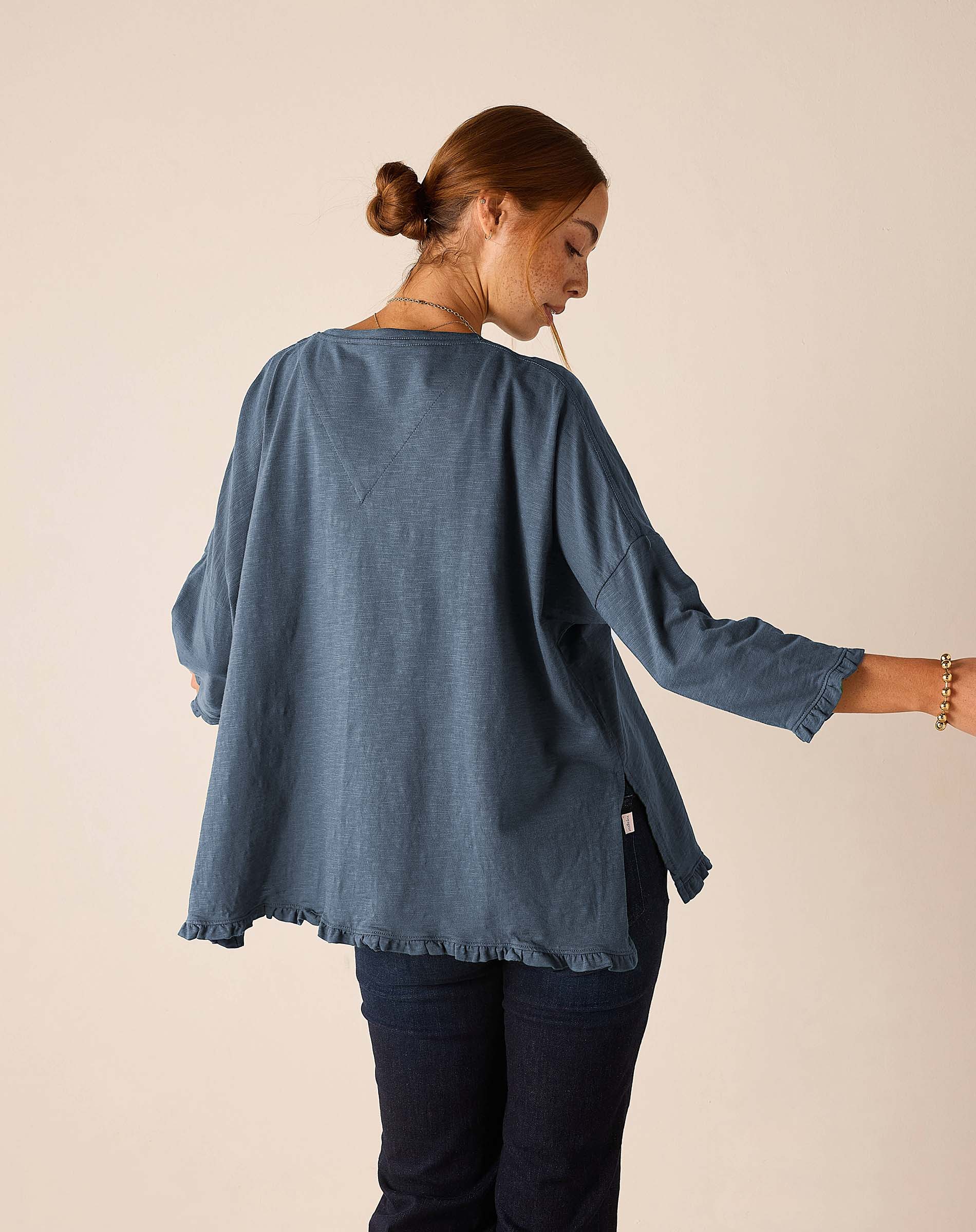 Back view of the slate blue ruffled tee with 3/4 sleeves and a relaxed fit.