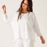 Woman wearing a white outfit against a plain background