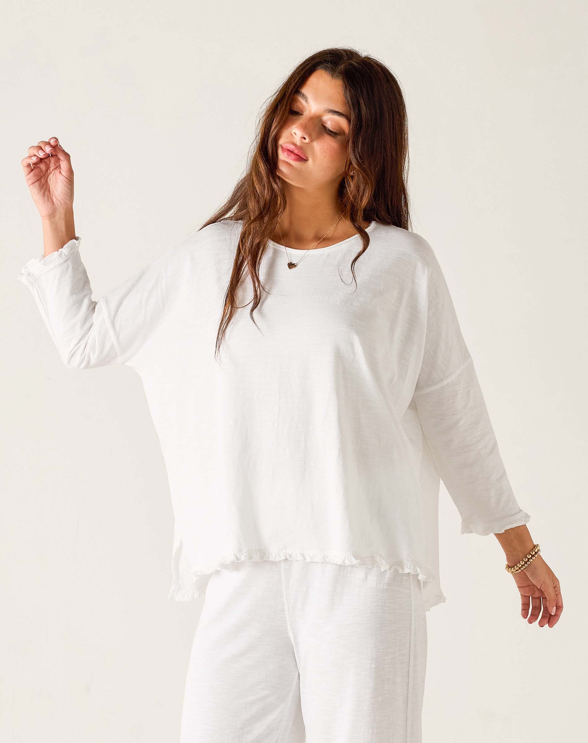 Woman wearing a white outfit against a plain background