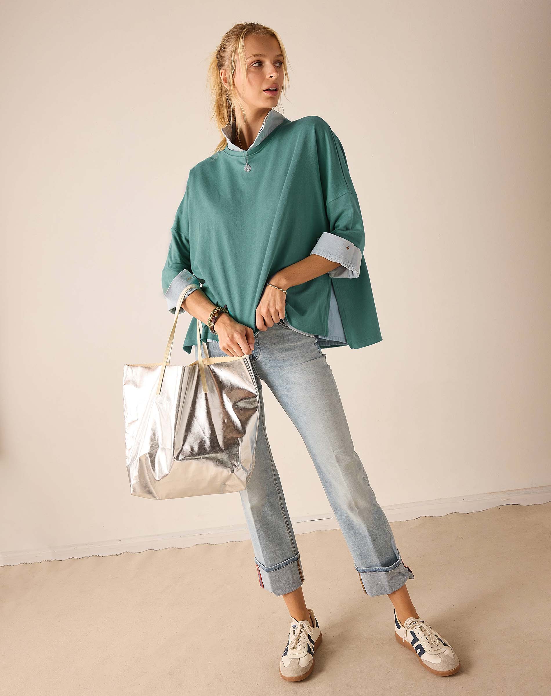 Aqua blue relaxed-fit knit top with half-zip and folded cuffs.