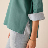 Aqua blue t-shirt featuring a buttoned cuff detail and subtle texture.