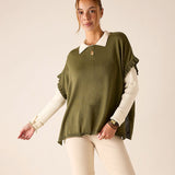 Moss green ruffled knit sweater worn over a white collared shirt with cream pants.