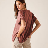 Burnt brick short-sleeve knit top with ruffled edges and a relaxed fit.