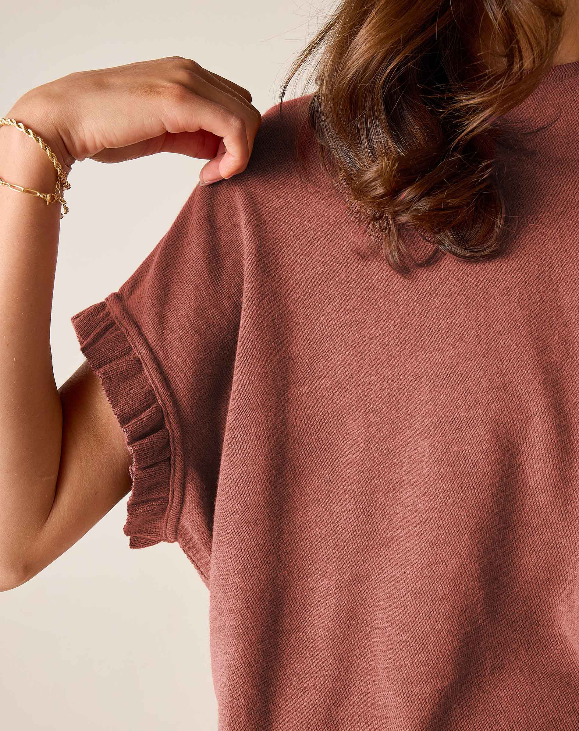 Burnt brick short-sleeve knit sweater with a ruffled edge and textured weave.