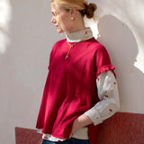 Jester red short-sleeve knit top with a ruffled hem and accented white patterned sleeves.