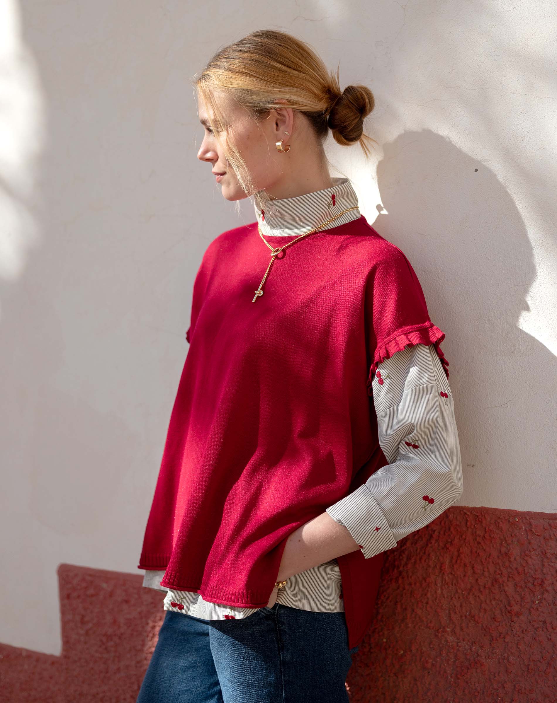 Jester red short-sleeve knit top with a ruffled hem and accented white patterned sleeves.