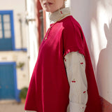 Jester red short-sleeve sweater over a button-up shirt featuring cherry motifs.