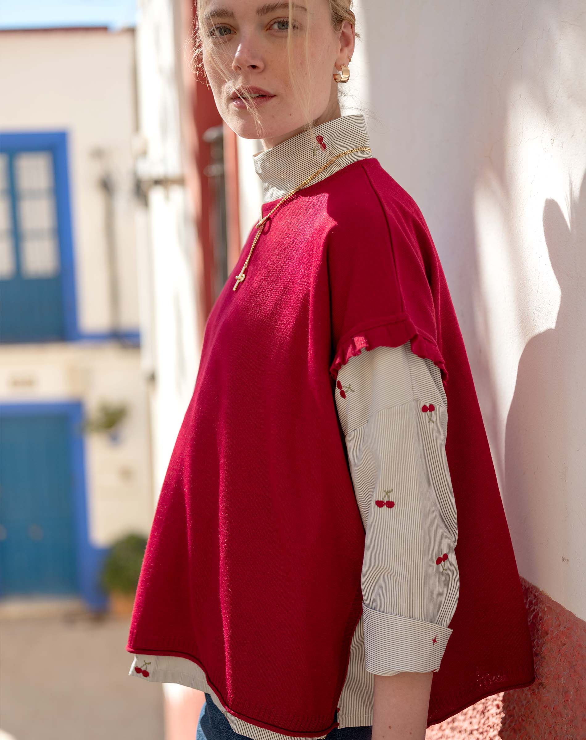 Jester red short-sleeve sweater over a button-up shirt featuring cherry motifs.