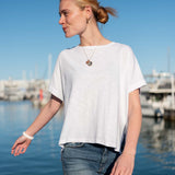 Women's travel-friendly white short-sleeve tee with a relaxed fit and wide neckline in a soft jersey texture.